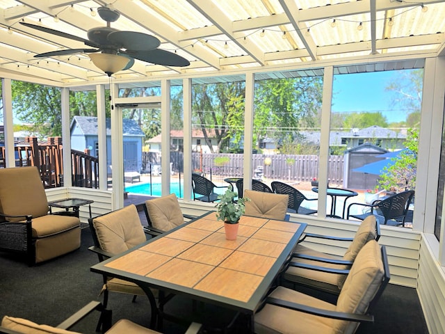 sunroom featuring outdoor dining area and ceiling fan