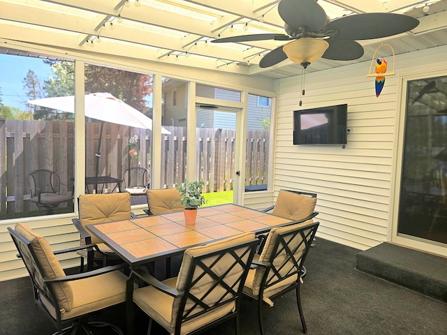 sunroom with outdoor dining area, a ceiling fan, and rail lighting