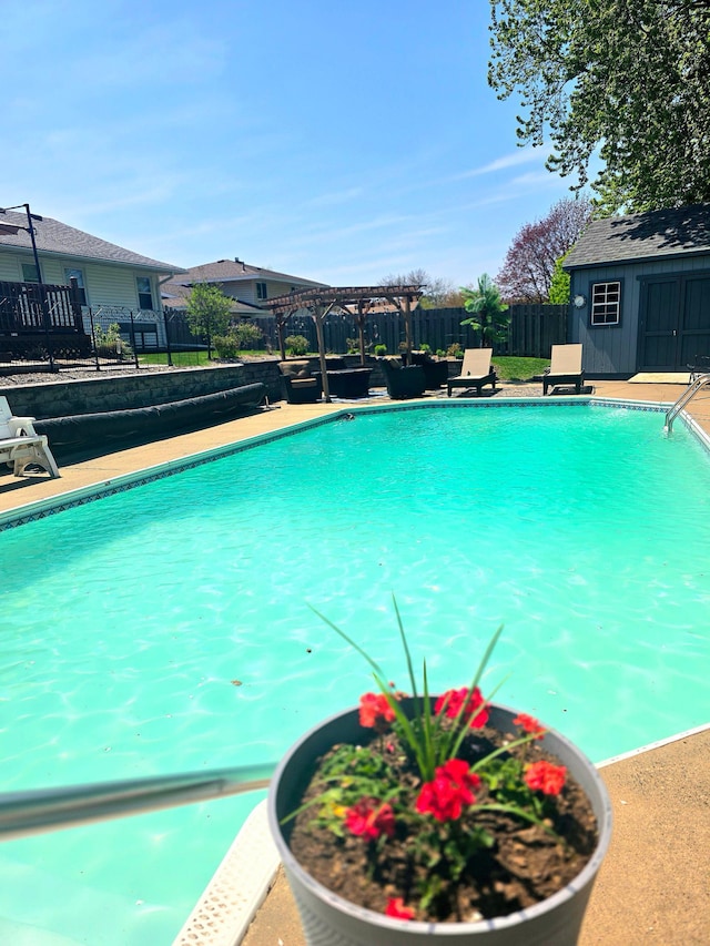 view of pool featuring a fenced backyard, an outdoor structure, and a pergola