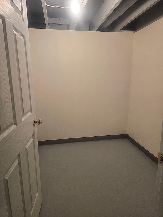 spare room featuring carpet floors and baseboards