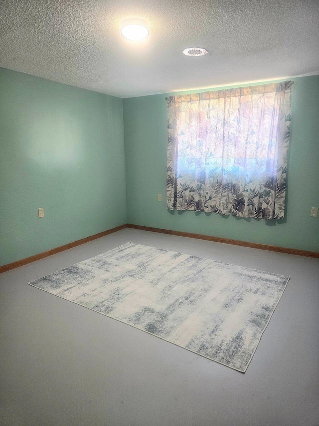 empty room with a textured ceiling and recessed lighting