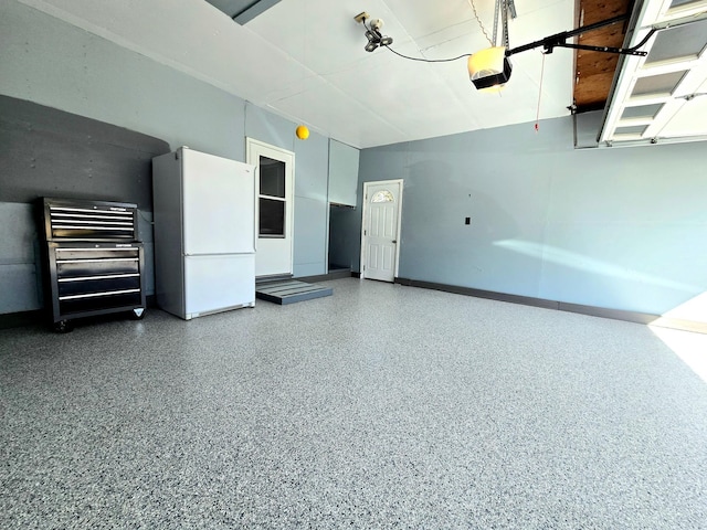 garage with freestanding refrigerator and a garage door opener
