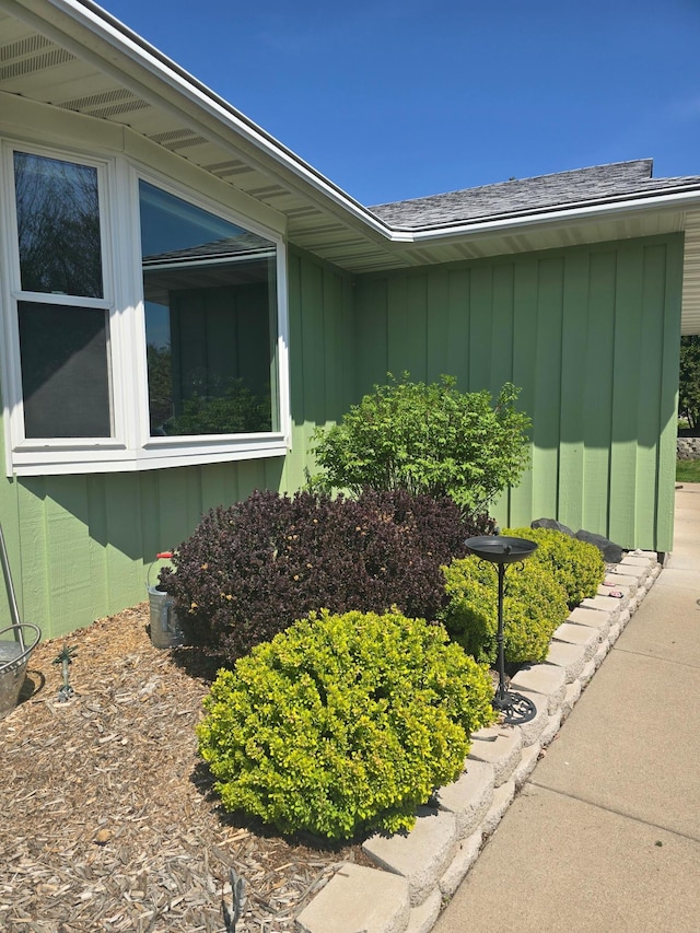 view of property exterior featuring board and batten siding and roof with shingles