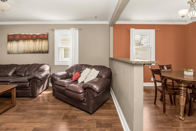 living room with wood finished floors, crown molding, and baseboards