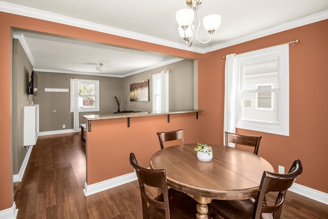 dining room with dark wood-type flooring, a chandelier, baseboards, and ornamental molding