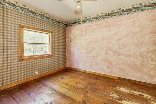 unfurnished room with wood-type flooring, baseboards, wallpapered walls, and ceiling fan