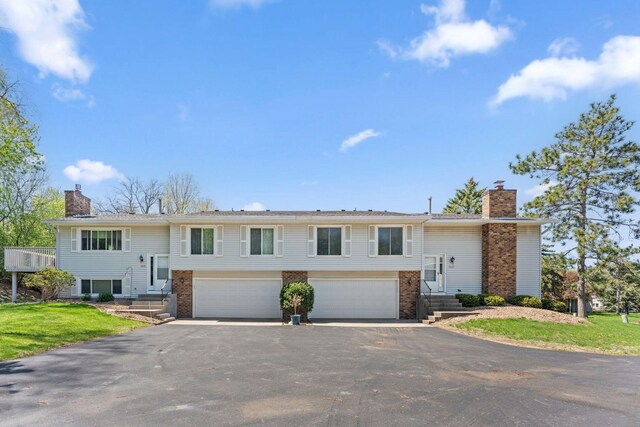 1635 140th St, Burnsville, MN 55337 - bi-level home with a chimney, asphalt driveway, brick siding, and a garage