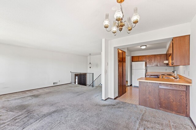 1635 140th St, Burnsville, MN 55337 - kitchen with freestanding refrigerator, brown cabinets, light carpet, a chandelier, and open floor plan