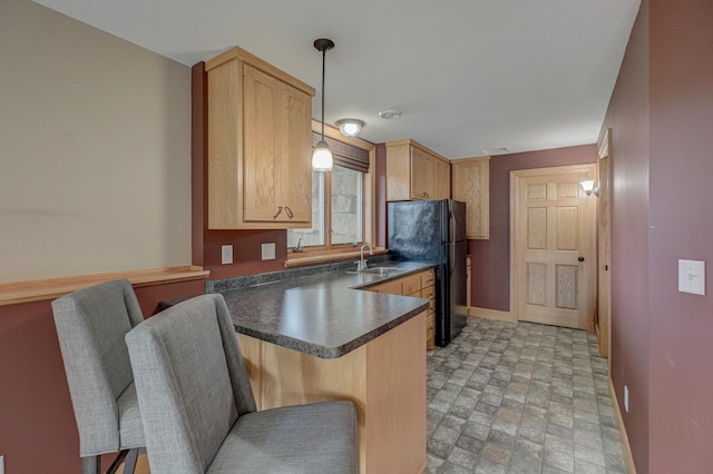 347 Glover Rd, Troy Twp, WI 54022 - kitchen with freestanding refrigerator, baseboards, a sink, a peninsula, and dark countertops
