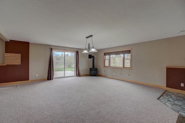 347 Glover Rd, Troy Twp, WI 54022 - interior space featuring baseboards, a wood stove, a healthy amount of sunlight, and carpet flooring