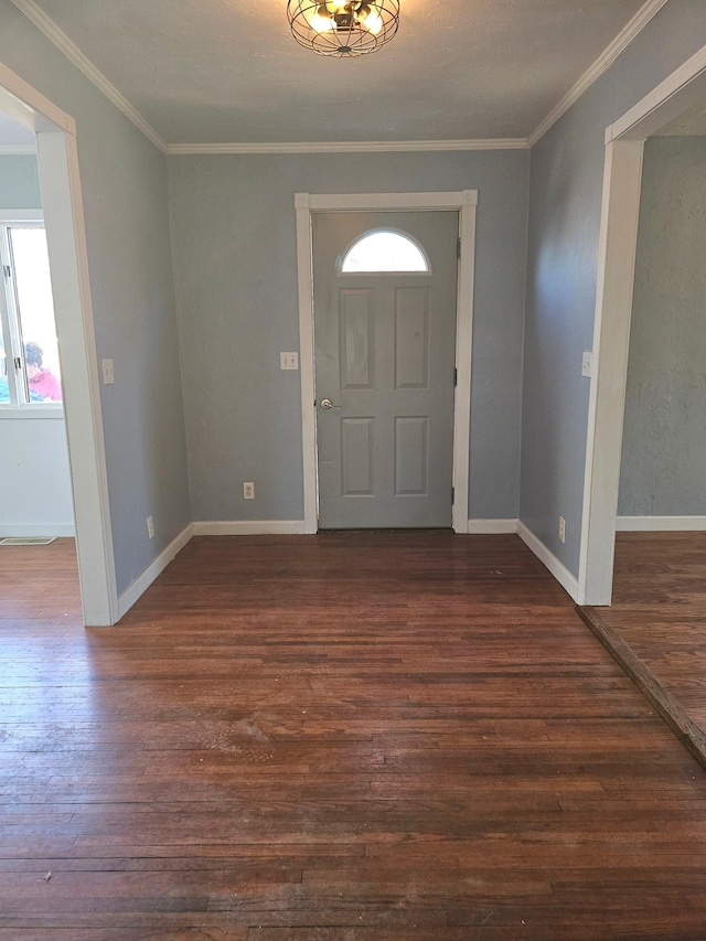 foyer entrance featuring healthy amount of natural light, dark wood-style flooring, ornamental molding, and baseboards