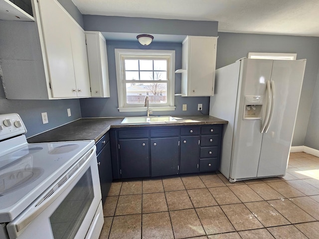 kitchen with white appliances, a sink, light tile patterned floors, and white cabinets