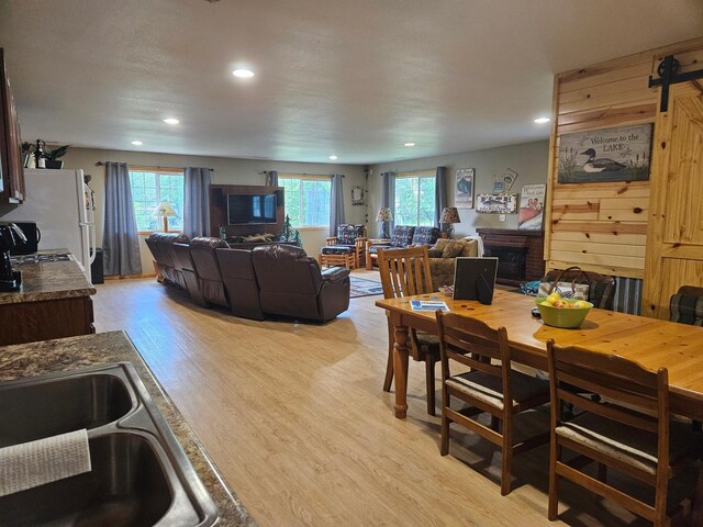 36282 Rush Lake Loop Unit 29A, Ottertail, MN 56571 - dining room with light wood-type flooring, recessed lighting, a brick fireplace, and a barn door