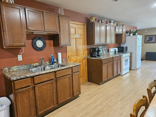 36282 Rush Lake Loop Unit 29A, Ottertail, MN 56571 - kitchen with a sink, white appliances, light wood-type flooring, and brown cabinetry