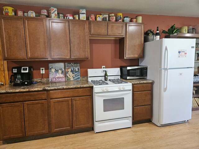 36282 Rush Lake Loop Unit 29A, Ottertail, MN 56571 - kitchen with white appliances, light wood-style floors, and brown cabinetry