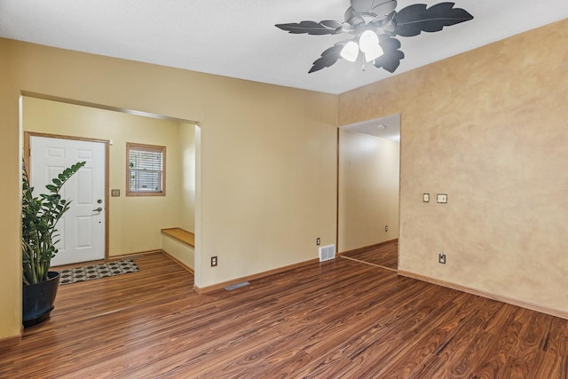 empty room featuring wood finished floors, ceiling fan, and baseboards