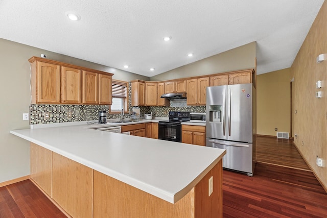 kitchen featuring stainless steel refrigerator with ice dispenser, black range with electric cooktop, under cabinet range hood, white microwave, and a peninsula
