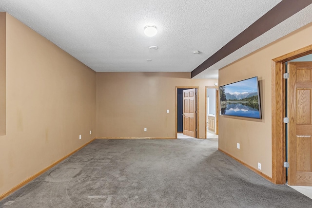 carpeted empty room featuring a textured ceiling and baseboards