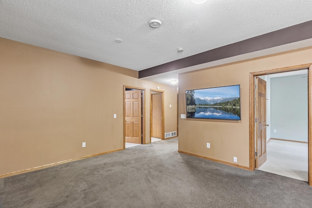 carpeted empty room with baseboards, a textured ceiling, and a smoke detector