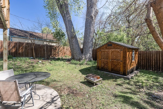 view of yard with outdoor dining area, a shed, an outbuilding, and an outdoor fire pit