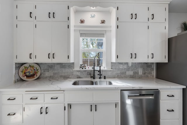 kitchen featuring backsplash, dishwasher, white cabinets, and a sink
