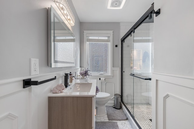 full bath featuring toilet, wainscoting, a shower stall, tile patterned flooring, and vanity