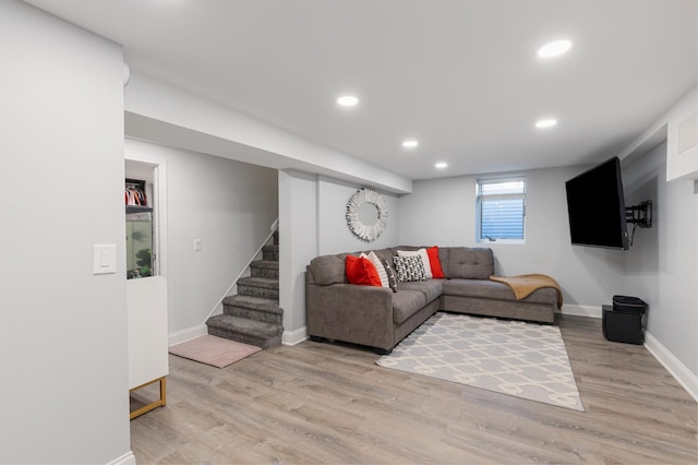 living area with light wood-style floors, baseboards, stairs, and recessed lighting