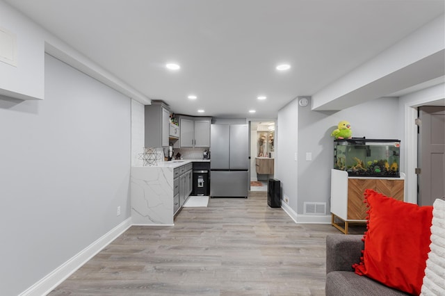 kitchen with freestanding refrigerator, gray cabinets, visible vents, light countertops, and recessed lighting
