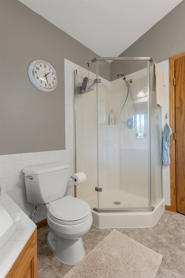 1282 141st Ln NW, Andover, MN 55304 - full bathroom with a stall shower, vanity, a textured ceiling, tile walls, and a wainscoted wall