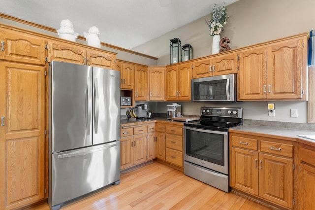 1282 141st Ln NW, Andover, MN 55304 - kitchen featuring appliances with stainless steel finishes, vaulted ceiling, light wood-style floors, and brown cabinetry