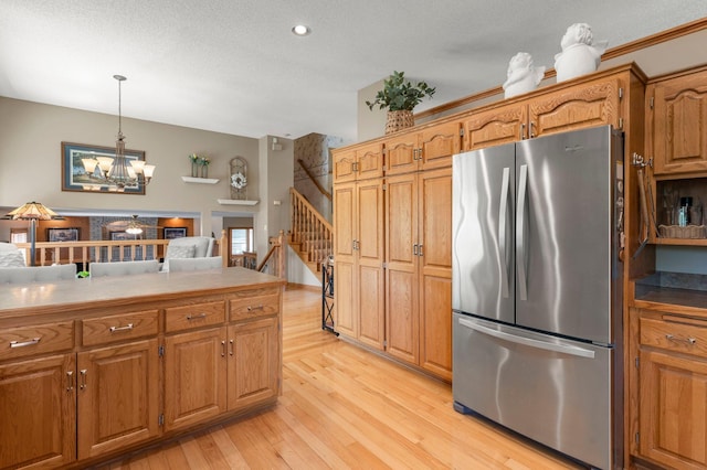 1282 141st Ln NW, Andover, MN 55304 - kitchen featuring freestanding refrigerator, light wood-type flooring, brown cabinets, recessed lighting, and a textured ceiling