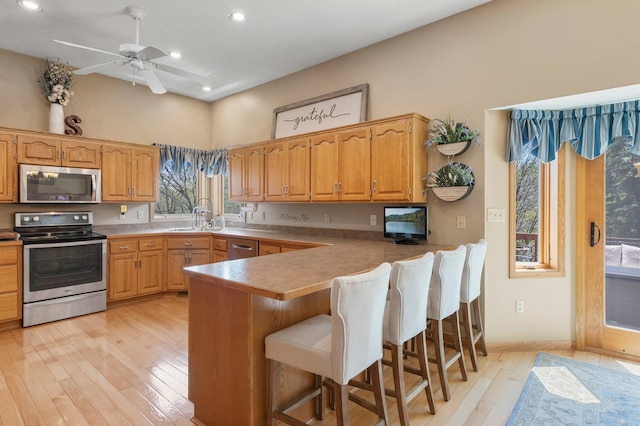 1282 141st Ln NW, Andover, MN 55304 - kitchen with appliances with stainless steel finishes, recessed lighting, a peninsula, light wood-type flooring, and a breakfast bar