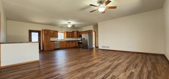 kitchen with stainless steel appliances, dark wood-type flooring, visible vents, a ceiling fan, and dark countertops