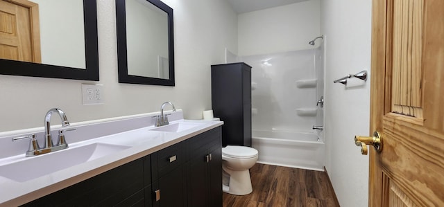 full bath with a sink, shower / bathing tub combination, toilet, and wood finished floors