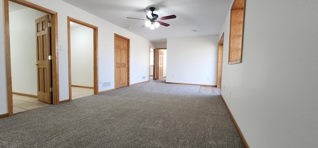 empty room featuring baseboards, ceiling fan, visible vents, and light colored carpet