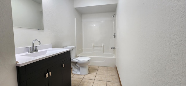 bathroom with toilet, tile patterned floors, vanity, and a textured wall
