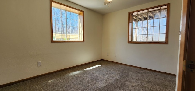 carpeted empty room featuring ceiling fan and baseboards