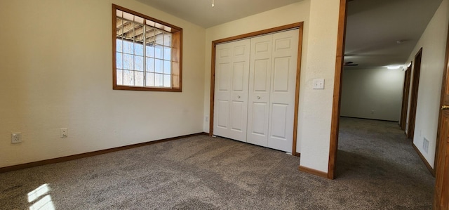 unfurnished bedroom with carpet flooring, a closet, and baseboards