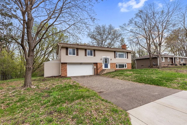 2409 Highland View Ave S, Burnsville, MN 55337 - bi-level home with brick siding, asphalt driveway, an attached garage, a chimney, and a front yard