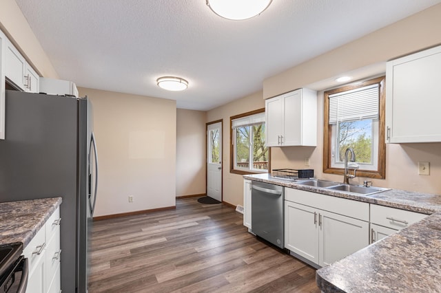 2409 Highland View Ave S, Burnsville, MN 55337 - kitchen featuring stainless steel appliances, a sink, wood finished floors, white cabinetry, and a textured ceiling