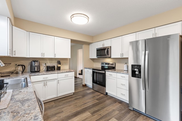 2409 Highland View Ave S, Burnsville, MN 55337 - kitchen with appliances with stainless steel finishes, dark wood-type flooring, white cabinets, a sink, and light stone countertops