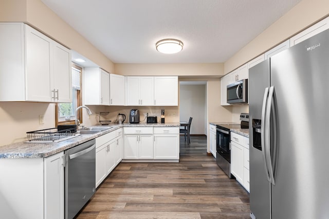 2409 Highland View Ave S, Burnsville, MN 55337 - kitchen with stainless steel appliances, a sink, wood finished floors, white cabinets, and light stone counters