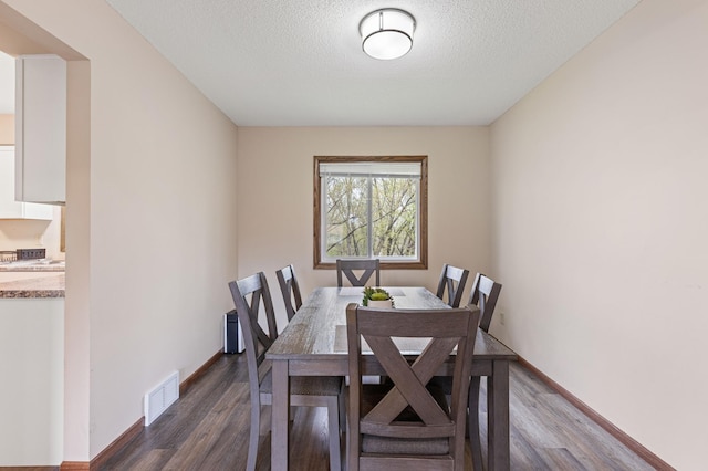 2409 Highland View Ave S, Burnsville, MN 55337 - dining space featuring dark wood finished floors, a textured ceiling, and baseboards