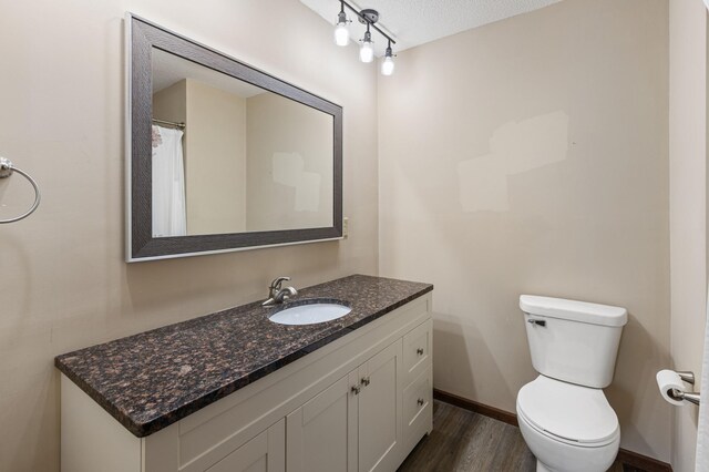 2409 Highland View Ave S, Burnsville, MN 55337 - bathroom featuring vanity, wood finished floors, toilet, baseboards, and a textured ceiling