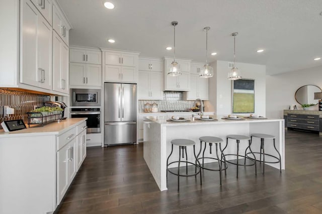 10833 38th Trl N, Lake Elmo, MN 55042 - kitchen featuring stainless steel appliances, backsplash, a breakfast bar area, light countertops, and recessed lighting