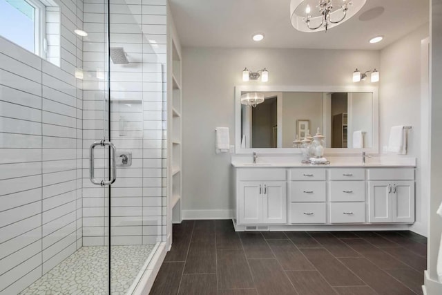 10833 38th Trl N, Lake Elmo, MN 55042 - bathroom with a chandelier, a shower stall, double vanity, recessed lighting, and baseboards