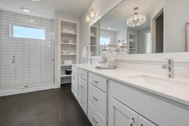 10833 38th Trl N, Lake Elmo, MN 55042 - bathroom featuring a shower stall, double vanity, built in shelves, and a chandelier