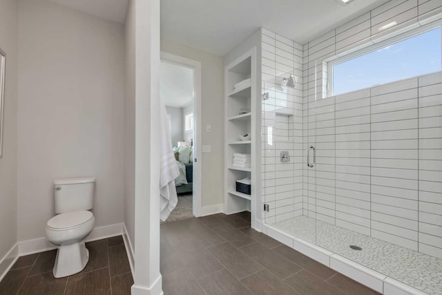 10833 38th Trl N, Lake Elmo, MN 55042 - ensuite bathroom with a stall shower, toilet, baseboards, and wood finish floors