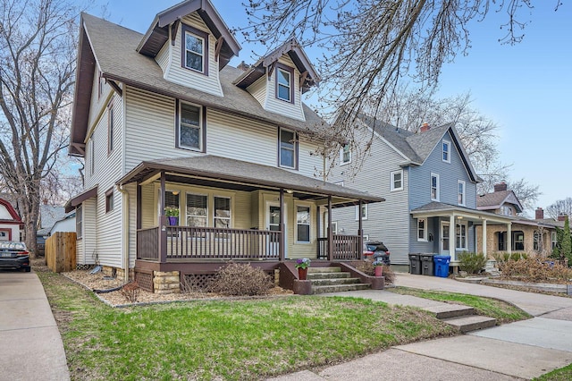 traditional style home with a porch and roof with shingles