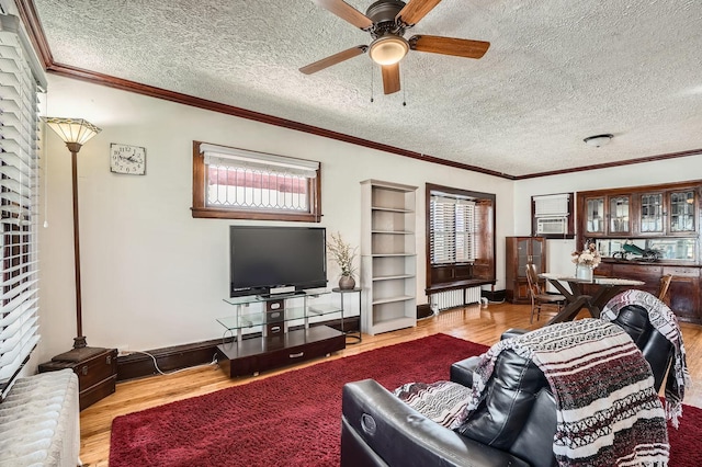 living room with a ceiling fan, a wealth of natural light, and wood finished floors
